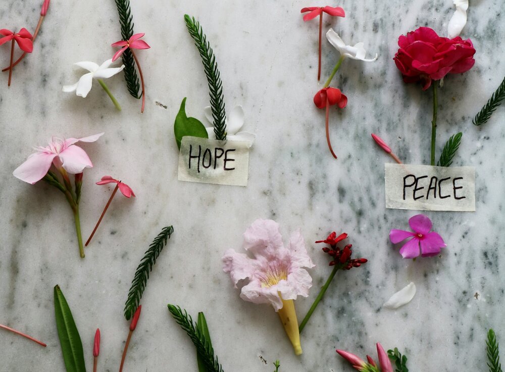 Marmor mit aufgeklebten Blumen und den handgeschriebenen Worten "Peace" und "Hope".